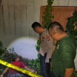 Petugas kepolisian saat melakukan olah tempat kejadian perkara (TKP) di pekarangan rumah kosong di Jalan Putri Rambut Selako, Kelurahan Bukit Lama, Kecamatan Ilir Barat I Palembang, lokasi ditemukannya seorang pria paruh baya dalam kondisi meninggal dunia, Minggu (4/1/2026) malam.